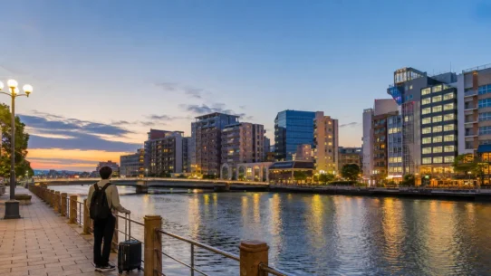 Traveler comparing budget hotels in Fukuoka near Hakata Station and Tenjin