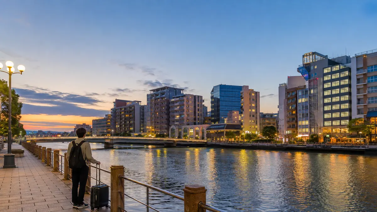 Traveler comparing budget hotels in Fukuoka near Hakata Station and Tenjin