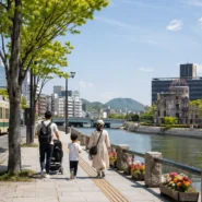 Family choosing a spacious hotel near Hiroshima Station with luggage and a stroller