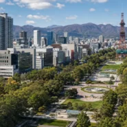 Seasonal views of Sapporo showing cherry blossoms, green summer parks, autumn foliage and winter snow