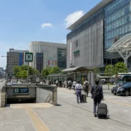 Traveler comparing subway, bus, taxi and walking routes from Hakata Station to central Fukuoka