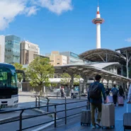Traveler comparing train, airport bus and private transfer options from Kansai Airport to Kyoto city center