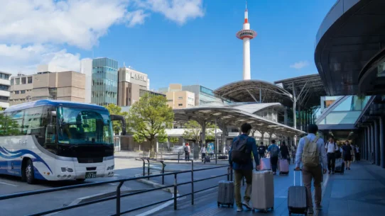 Traveler comparing train, airport bus and private transfer options from Kansai Airport to Kyoto city center