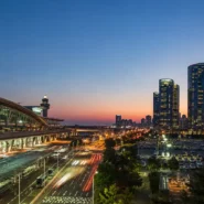 Traveler comparing AREX train, airport bus and taxi options from Incheon Airport to central Seoul
