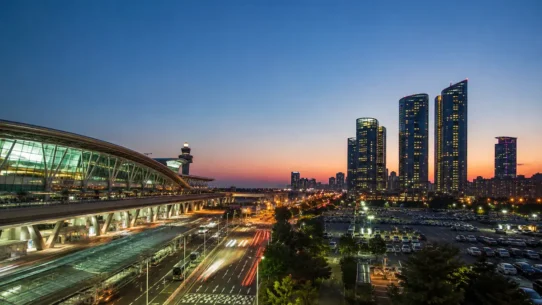 Traveler comparing AREX train, airport bus and taxi options from Incheon Airport to central Seoul